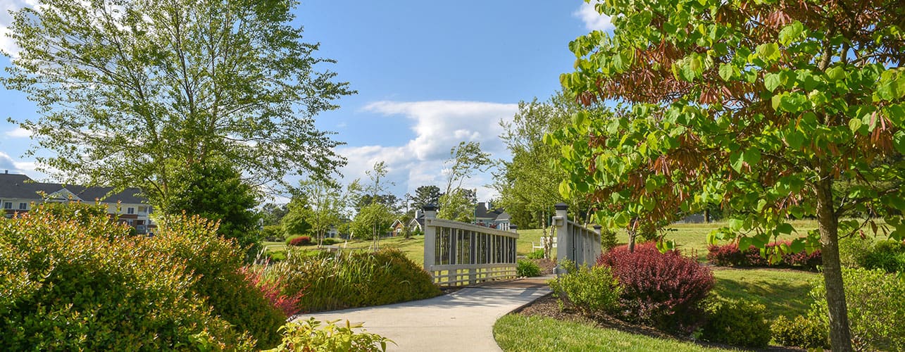 A sidewalk leading to a small bridge on the Covenant Woods campus.