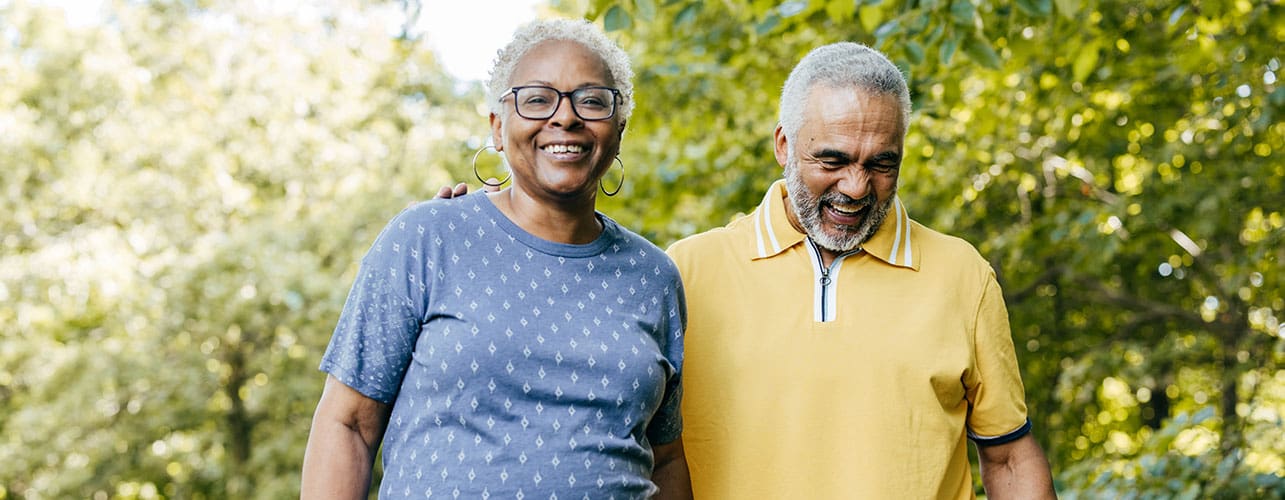 A senior couple walking outside on a beautiful spring morning.