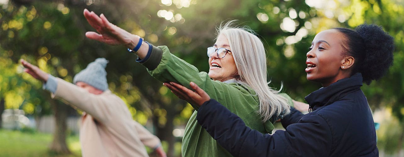 Group fitness class outside with help from a fitness instructor.