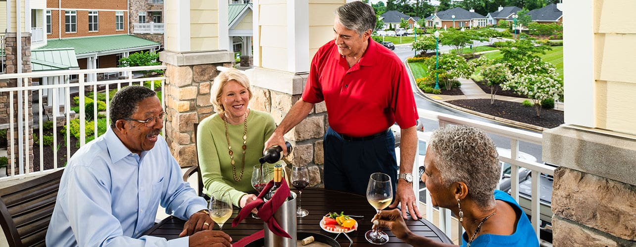 Friends dining outside on a terrace at Covenant Woods.